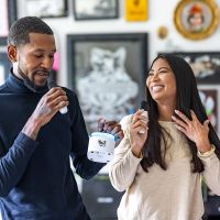 Smiling couple having fund singing into a portable Karaoke Machine.