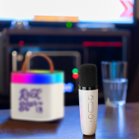 Portable Karaoke machine with Microphone and Glass sitting on a table