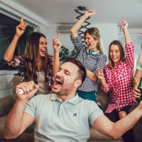 Friends and family Singing and having fun with portable Karaoke Machine at a party